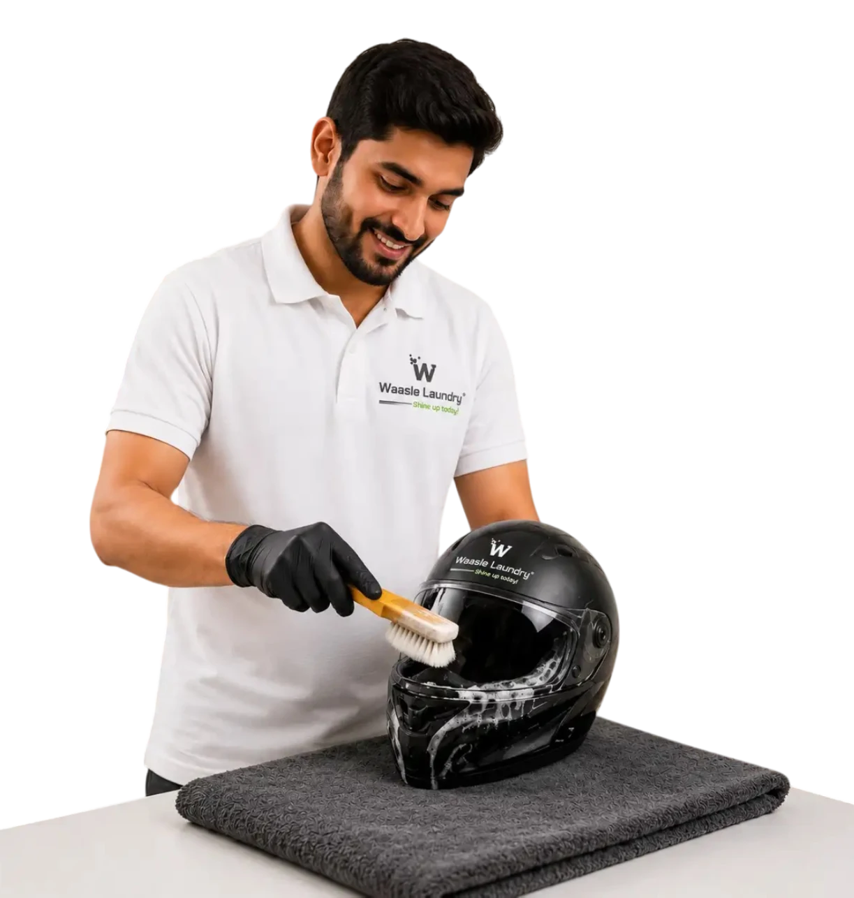 Waasle Laundry professional cleaning a black helmet with brush and foam.